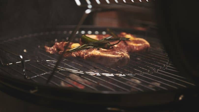 meat with herbs on a bbq grill rack