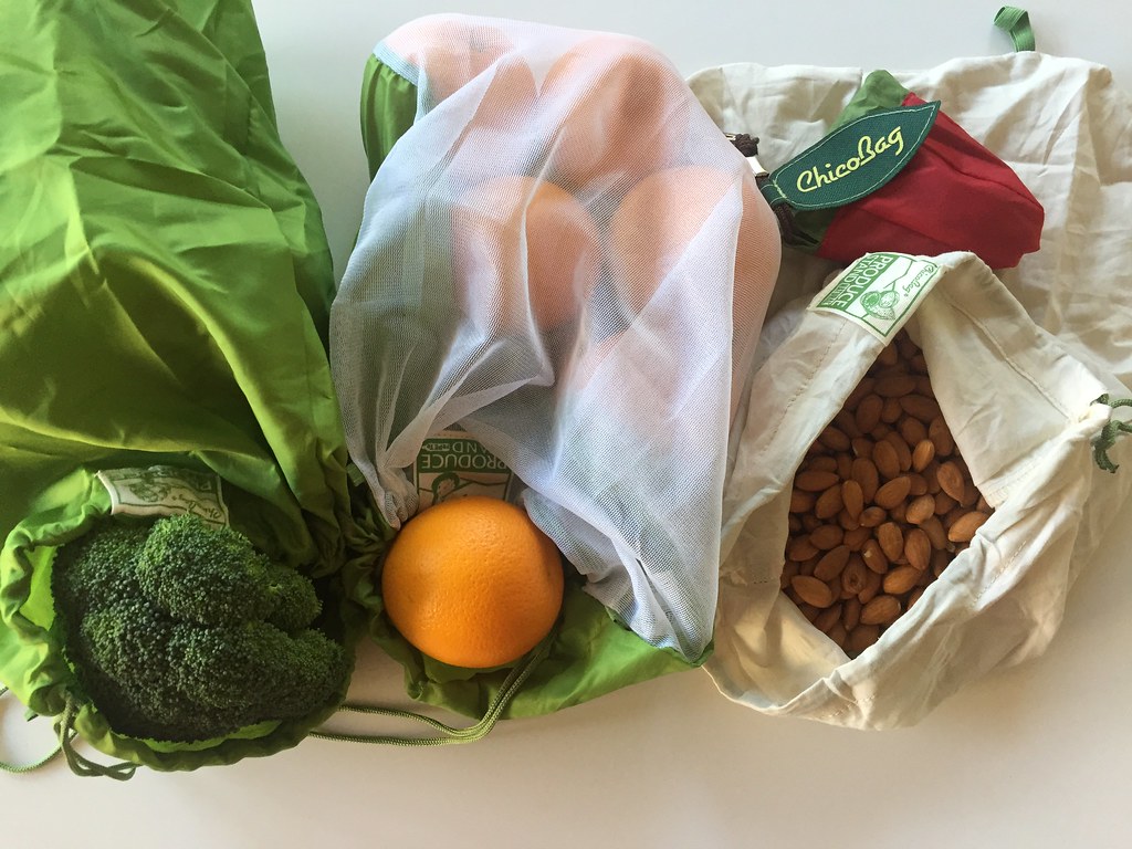 Assortment of fruits and vegetables inside reusable grocery bags