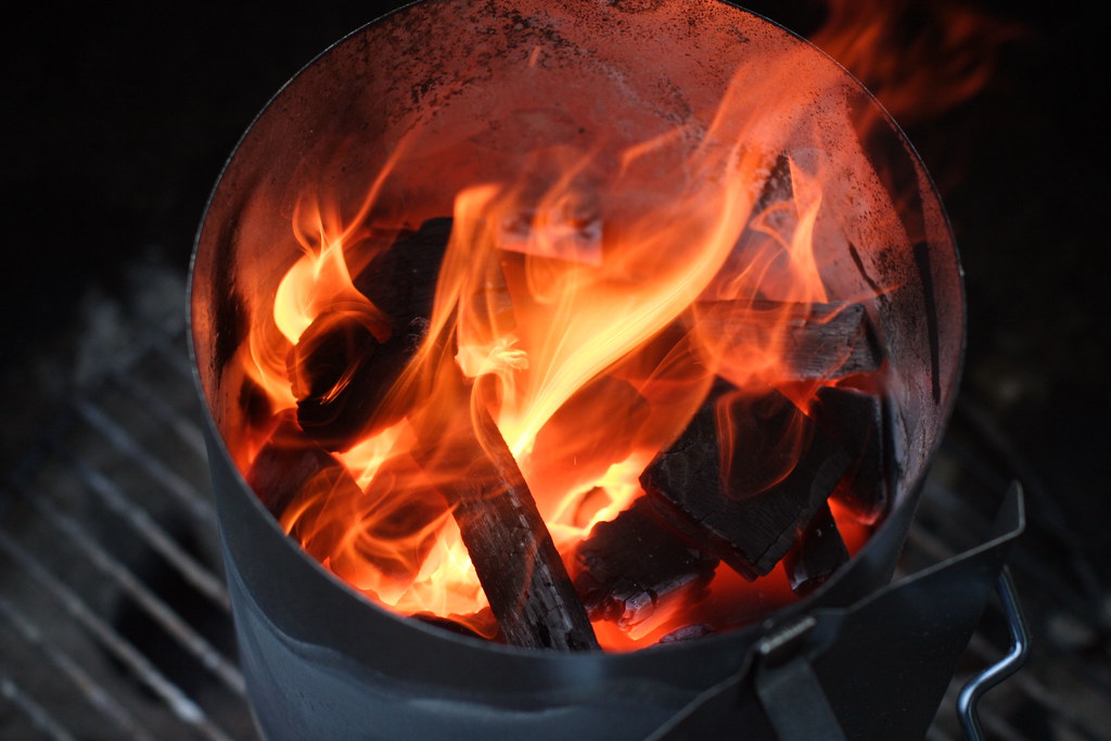 Up close shot of a lit charcoal chimney starter.