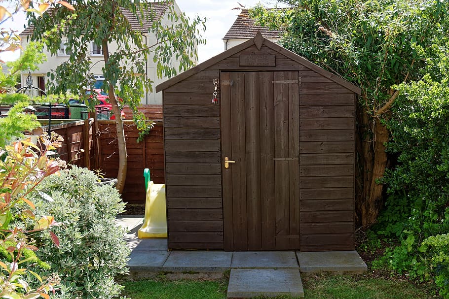 Wooden shed positioned in a small garden