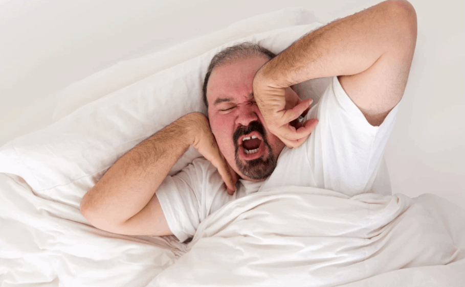 Man in bed yawning