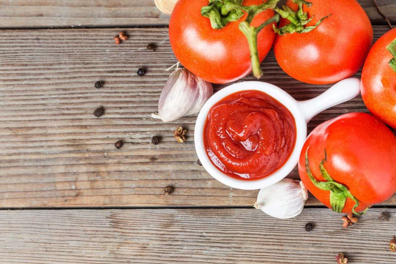 tomatoes, garlic and sauce on a wooden table