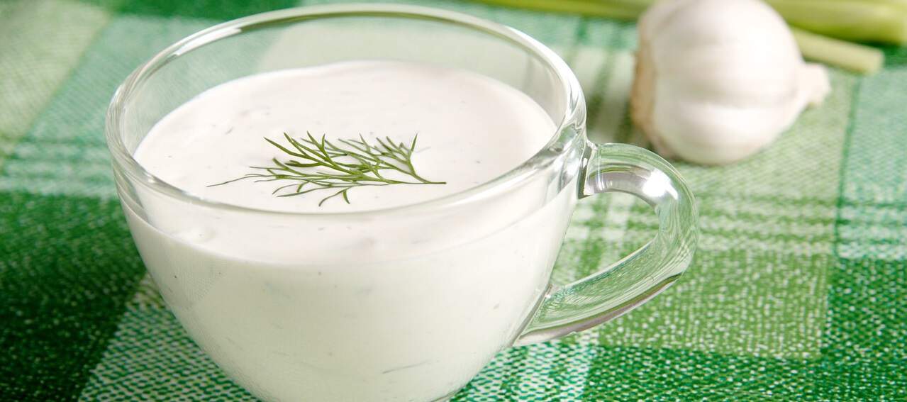 sour cream in glass cup on green tea towel