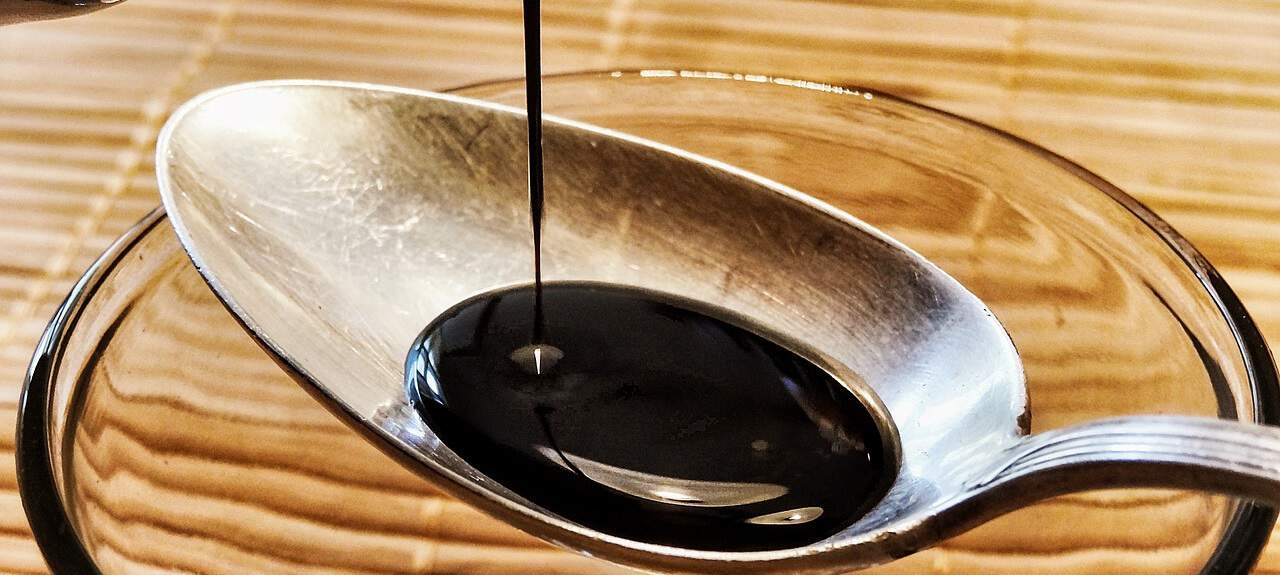 soy sauce pouring onto a spoon