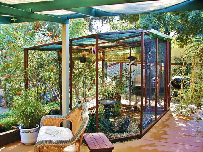 Outdoor bird aviary placed near a patio seating