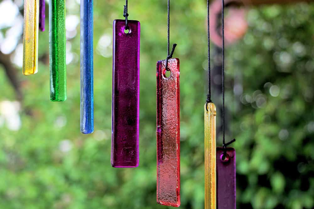 Colourful DIY wind chimes attached on a tree
