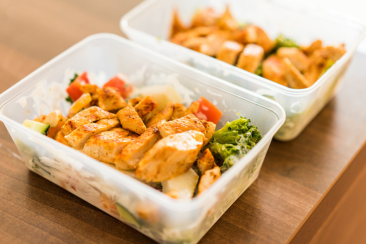 Prepped meal lunch boxes with grilled chicken and vegetables.
