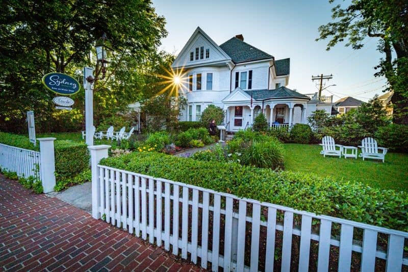 white picket fence house set back on a lawn