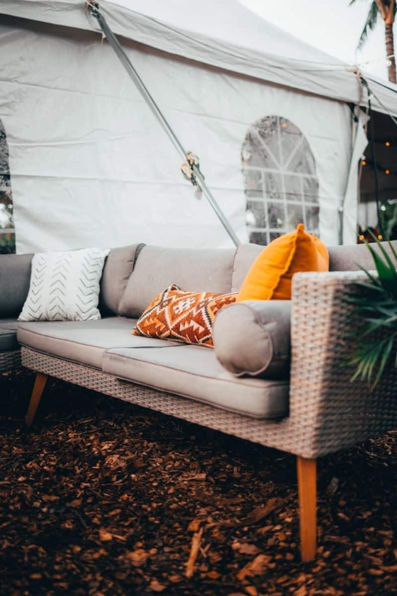 rattan outdoor sofa next to a marquee