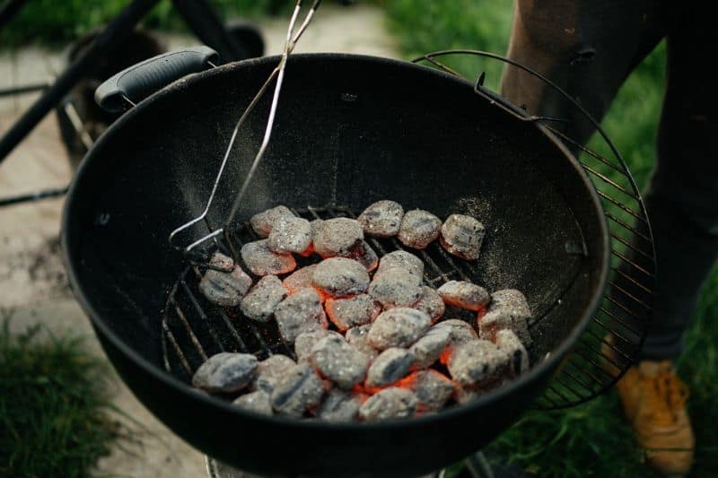 Burning charcoal briquettes on a kettle grill