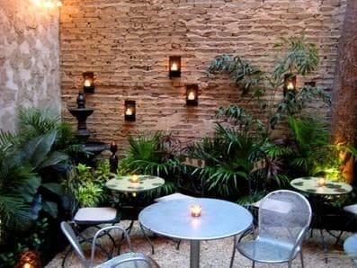 Bricks and plants with some hanging lights, creating a cosy dining space