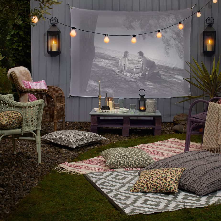 Courtyard cinema scene with striped outdoor rug that creates a cosy outward appearance