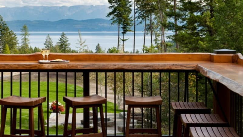 Built-in outdoor bar decks with a view of water past trees