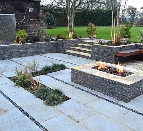 A contemporary courtyard featuring bright sandstone and a fire pit