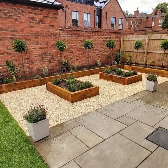 A neat backyard with a brown porcelain coloured deck and some pebbles for the raised garden