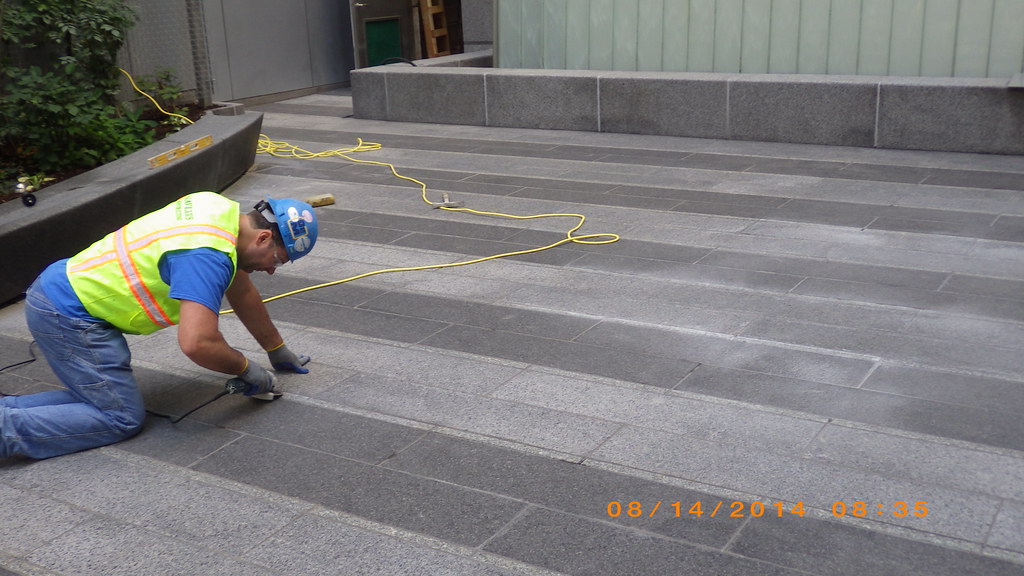A man fixing granite paving slabs