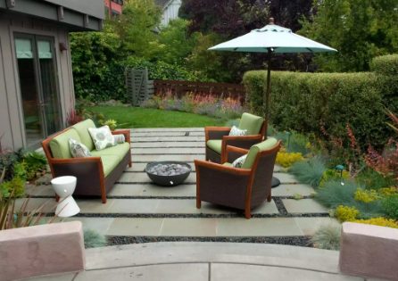 Small patio designed with Bluestone bands and black pebbles