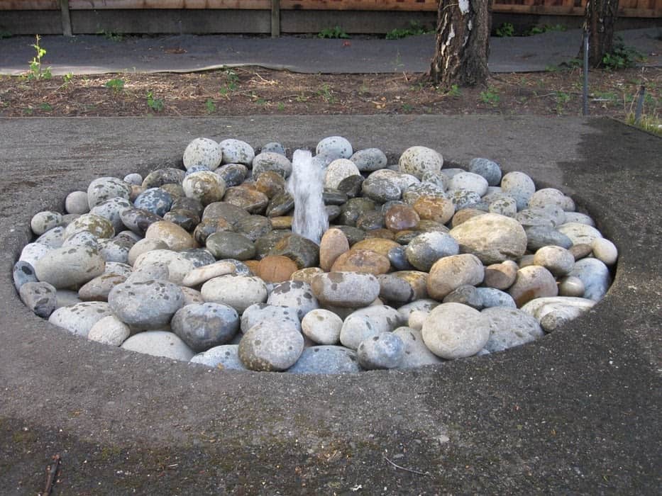 Disappearing water fountain with pebbles/stones surrounding it