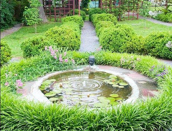 Mini round-shaped pond within a circular lawn border