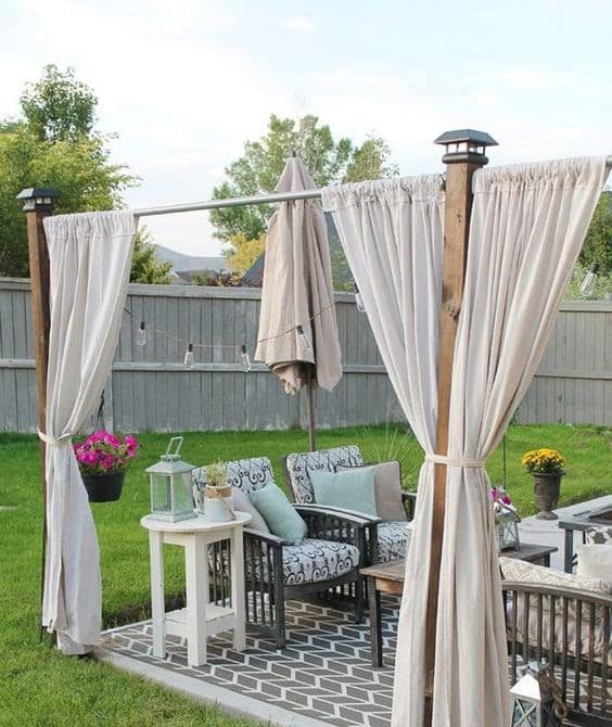 Separated outdoor dining with curtains and patio umbrella