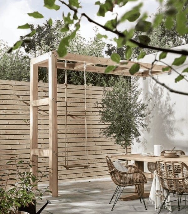 Light wood garden fence, alongside pale tones of grey and white outdoor fixtures