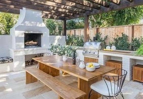 A Mediterranean-inspired outdoor dining set-up with fully furnished outdoor kitchen 