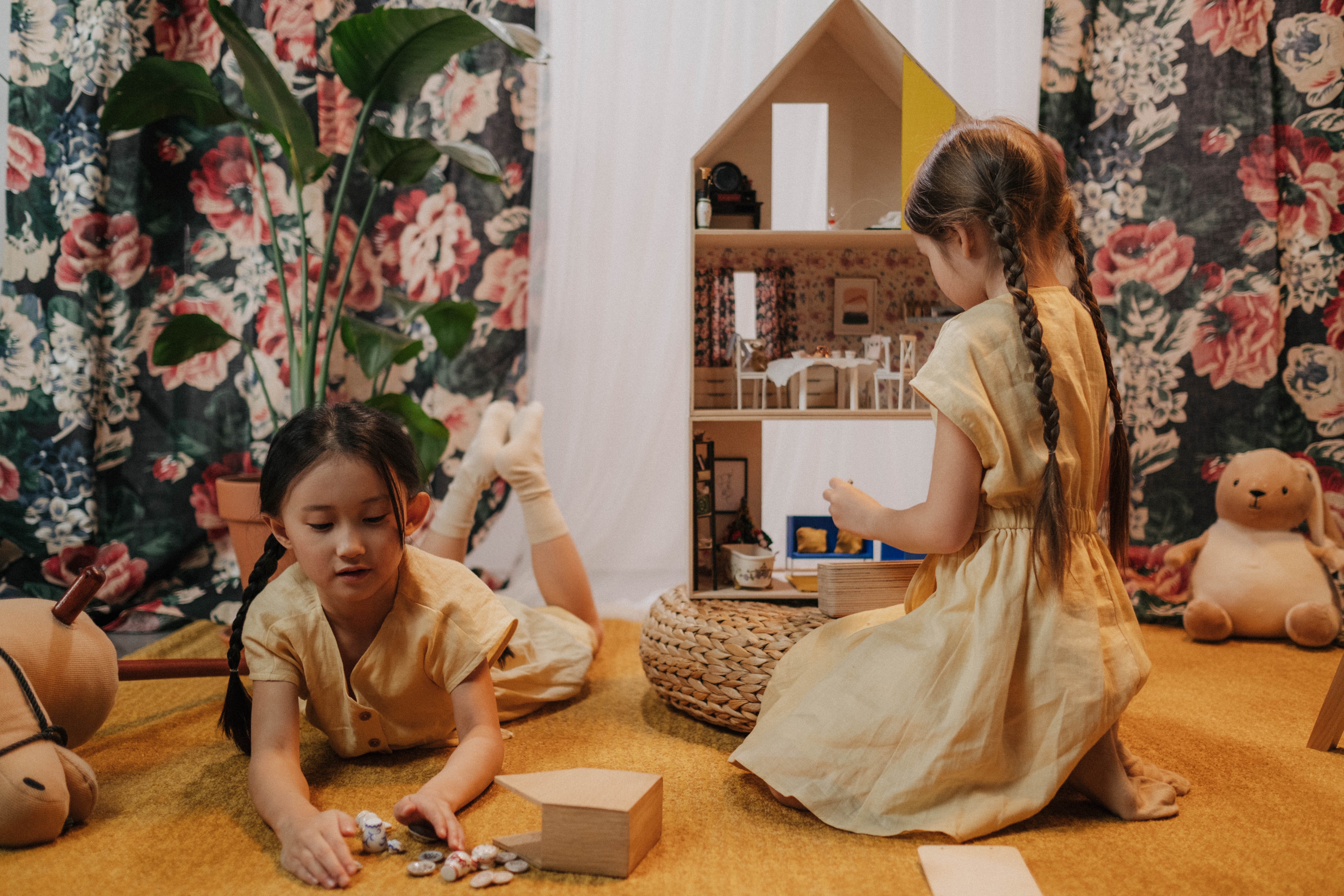 Two little girls playing a doll house