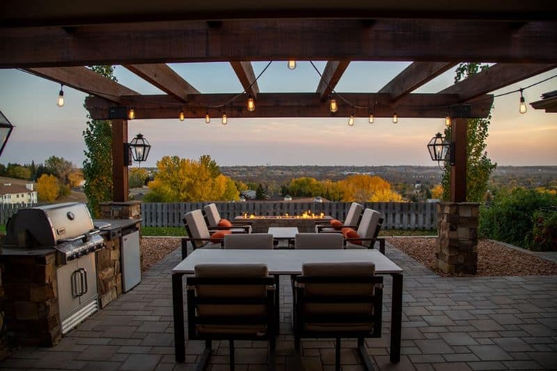 patio with built-in BBQ, table and chairs looking out over a sunset