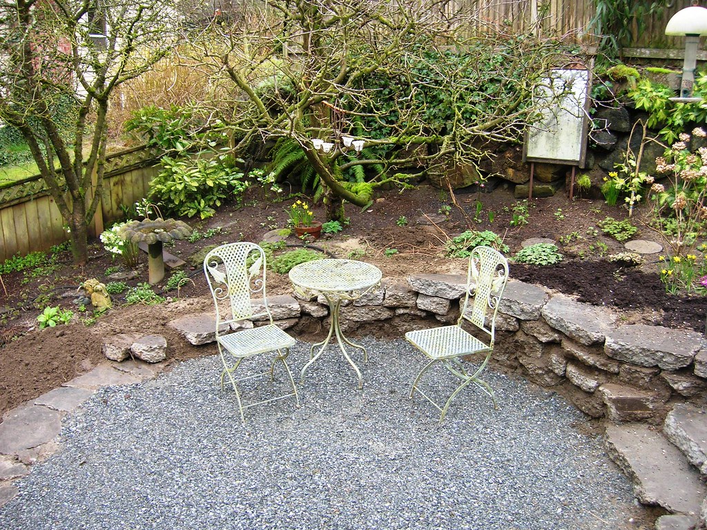 Simple gravel patio with wrought iron bistro seating
