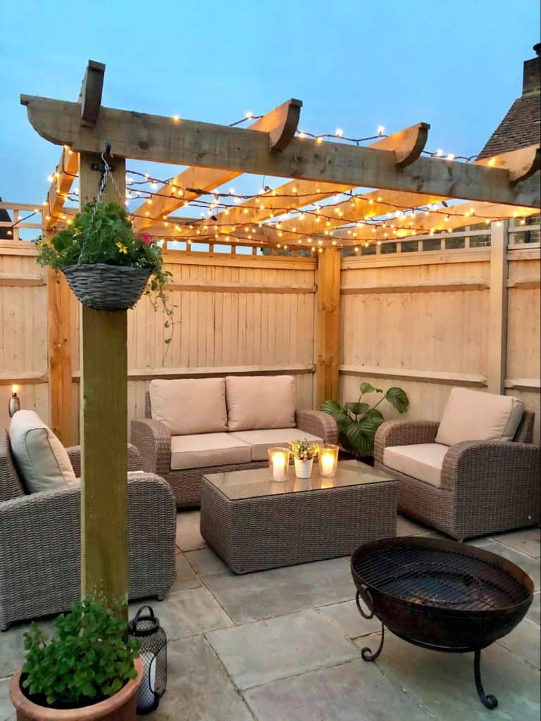 sofas under pergola with fairy lights