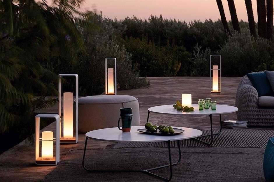 modern shape lighting with round white tables at dusk