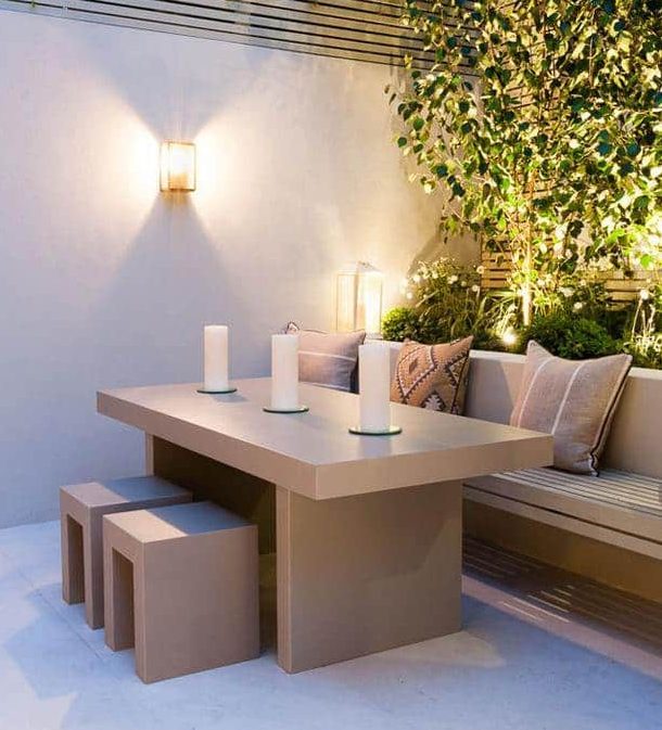 small garden lighting around beige marble table with cube chairs