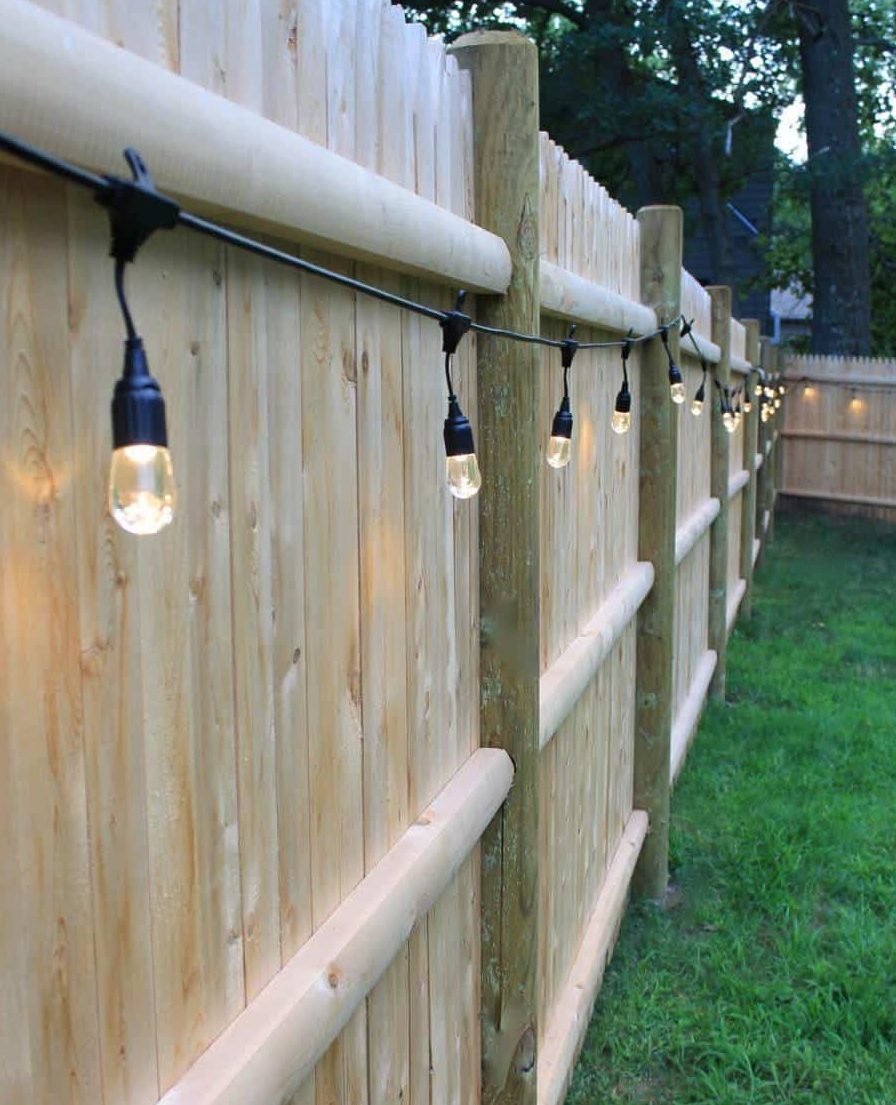 backyard lights hanging from a fence