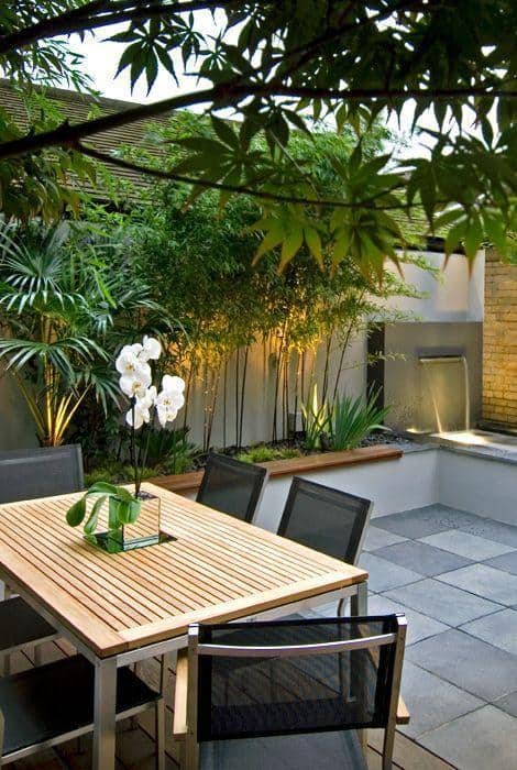 minimalist garden on tiled patio with table and chairs