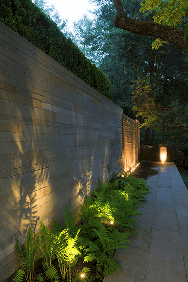 accent wall lighting with low growing shrubs