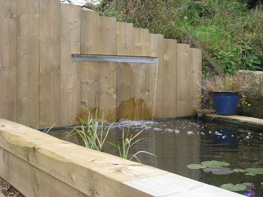 Garden pond with wooden wall retainer