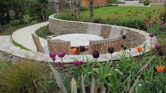 A round retaining wall into the hillside, creating a perfect space for outdoor dining