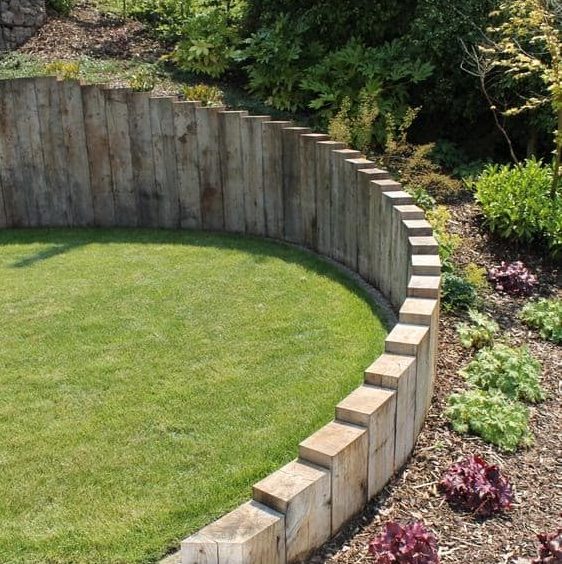 A levelled garden with a strong retaining wall on a messy sloped hill
