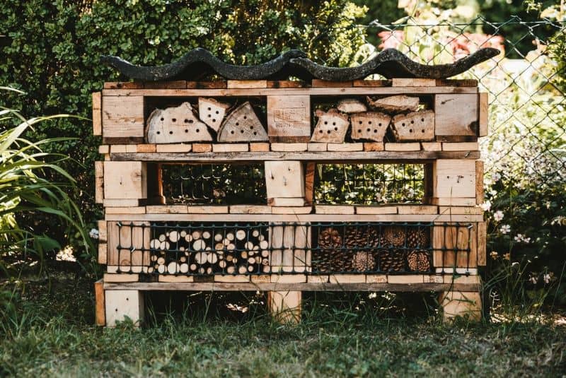 bug hotel stacked in pallets on grass