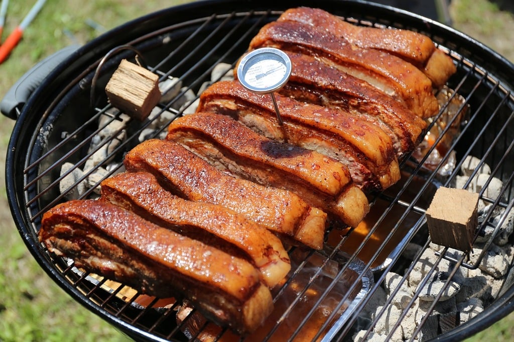 BBQ Checklist: A bbq with meat on a grill with a thermometer.