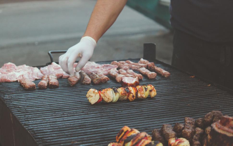 BBQ Checklist: Chef grilling a variety of meats and kebabs on a large barbecue grill.
