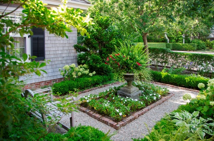 A garden decorated with arranged plants and stone patio
