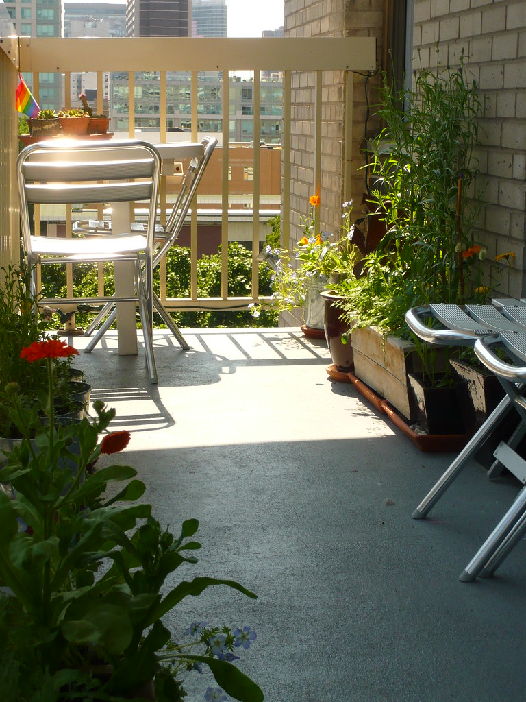 Small balcony with planters and garden chairs