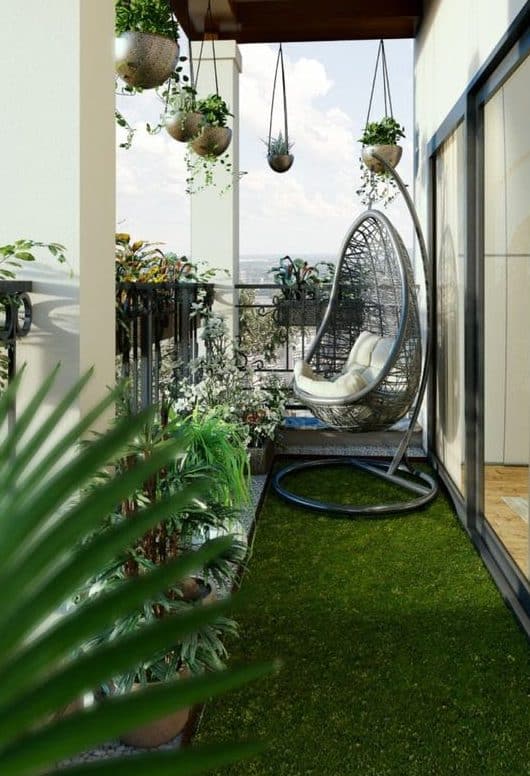 A small balcony with simple hanging plants and a comfortable, modern chair