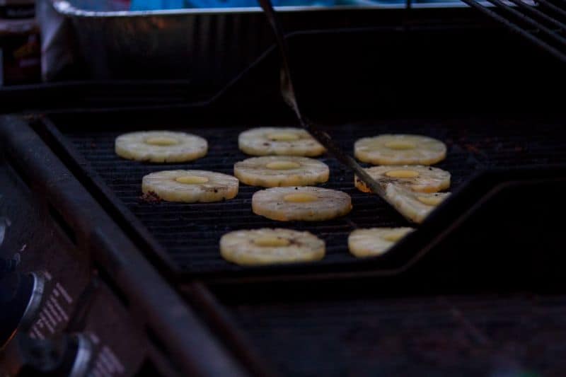 Chunks of pineapple being grilled on a gas BBQ grill