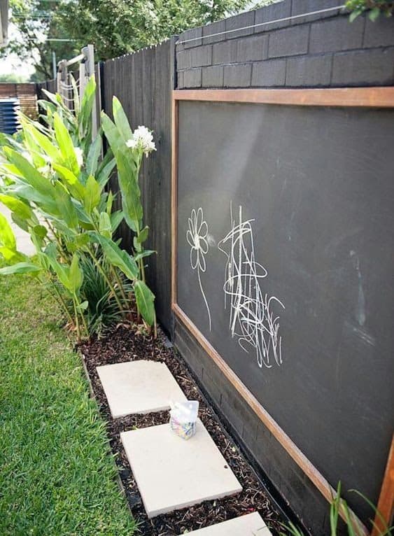 A blackboard installed along a wall for kids to practice drawing outdoors
