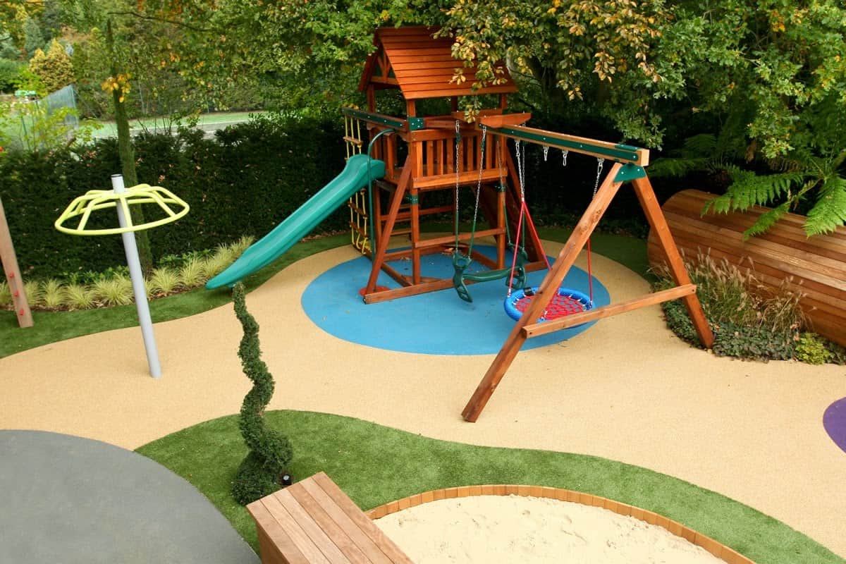 A playground set-up with slides and swings in a backyard