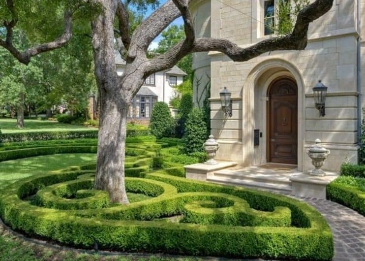 A front yard with mini garden maze made from hedges