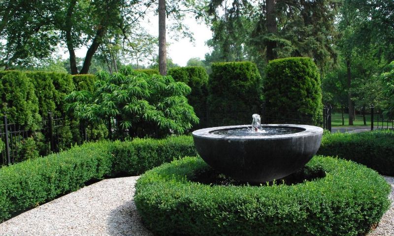 Garden hedges as a natural backdrop for a semi-globe water feature