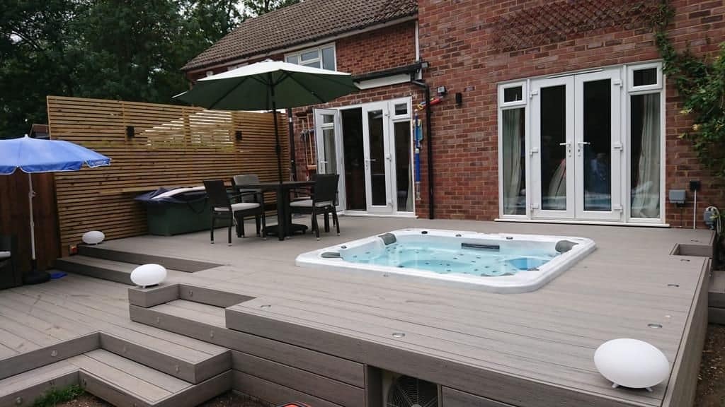 A hot tub deck with composite decking material